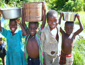 Young children bring water back to their village everyday. 