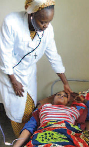 A Congolese Sister of Notre Dame de Namur checks on a patient. 