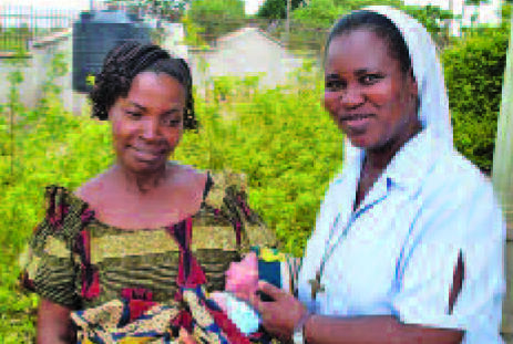A mother with her new baby thanks Sr. Prisca Igbozulike for the medical care she receives in Lagos.